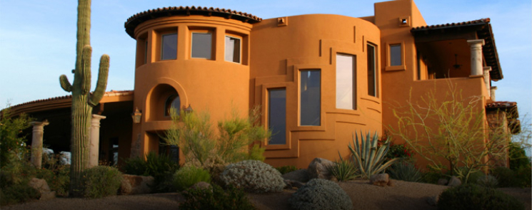 A large orange house surrounded by cactus plants, representing the security of personal assets.